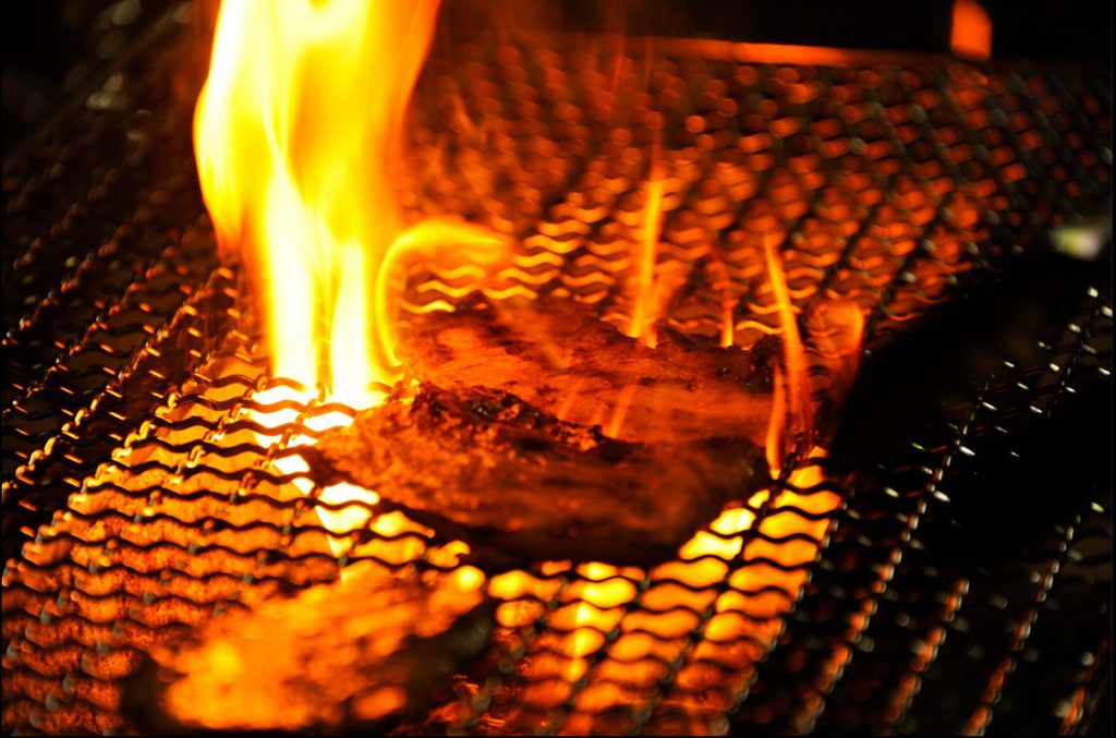 網で焼かれているお肉の写真撮影